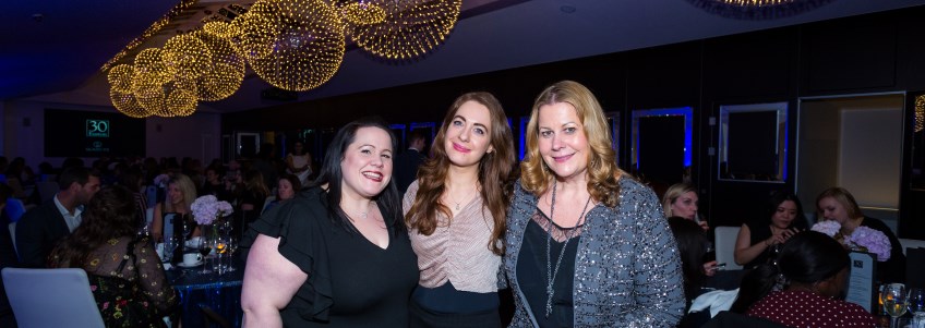 three ladies standing next to each other in the women in business event